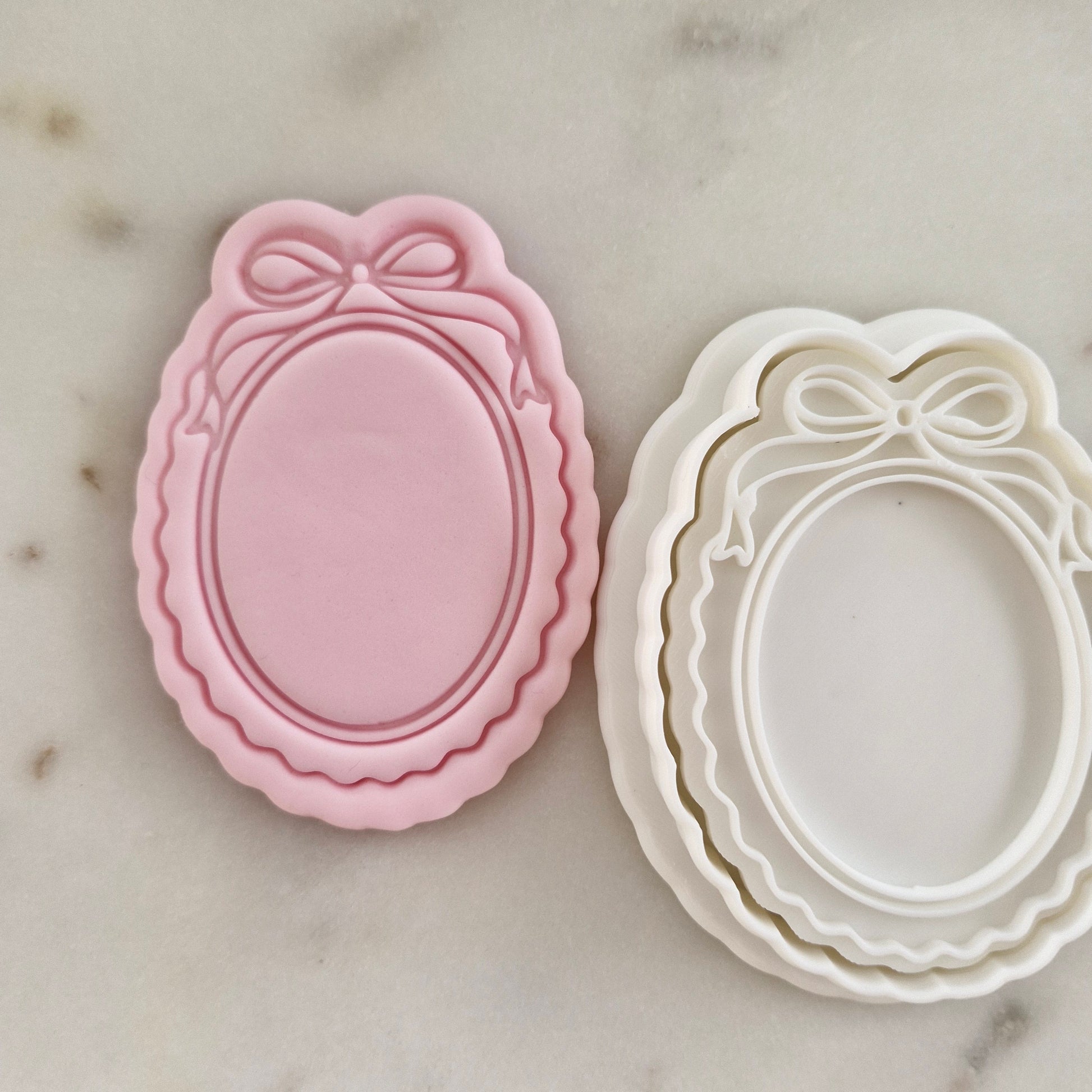 Set of cookie cutters with a pink and white design on a marble surface