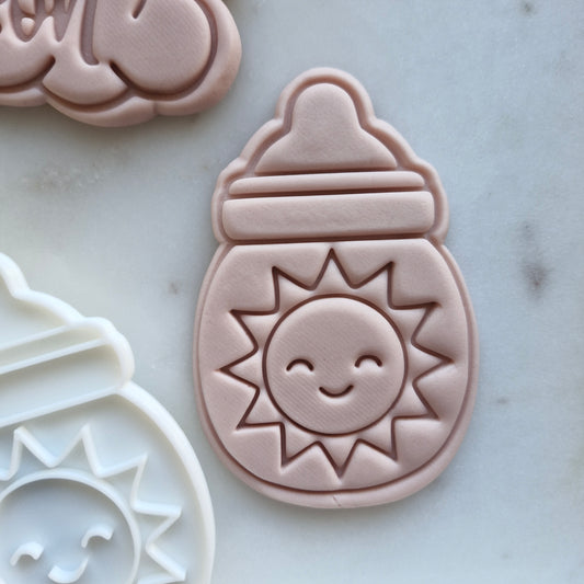Smiling Sun Cookie Cutter and Emboss Stamp - Baking Tool, zoomed in, marble background Here Comes the Son Set Cookie Cutter and Emboss Stamp - Baking Tool Here Comes the Son Set Cookie Cutter and Stamp Baking Tool Baby Bottle with Sun Cookie Cutter and Emboss Stamp - Baking Tool