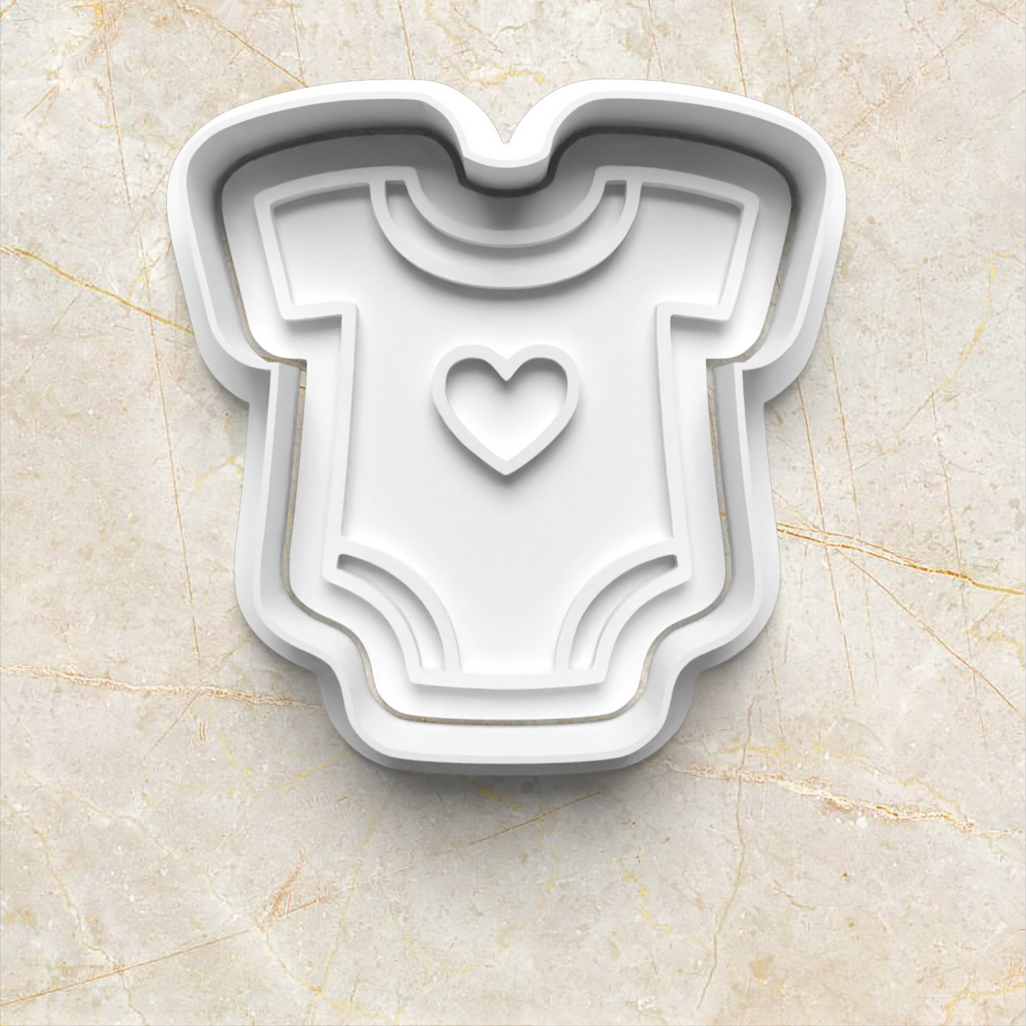 Baby Set Cookie Cutter and Emboss Stamp - Baking Tool in the shape of baby onesie with heart in the middle, on yellow marble background