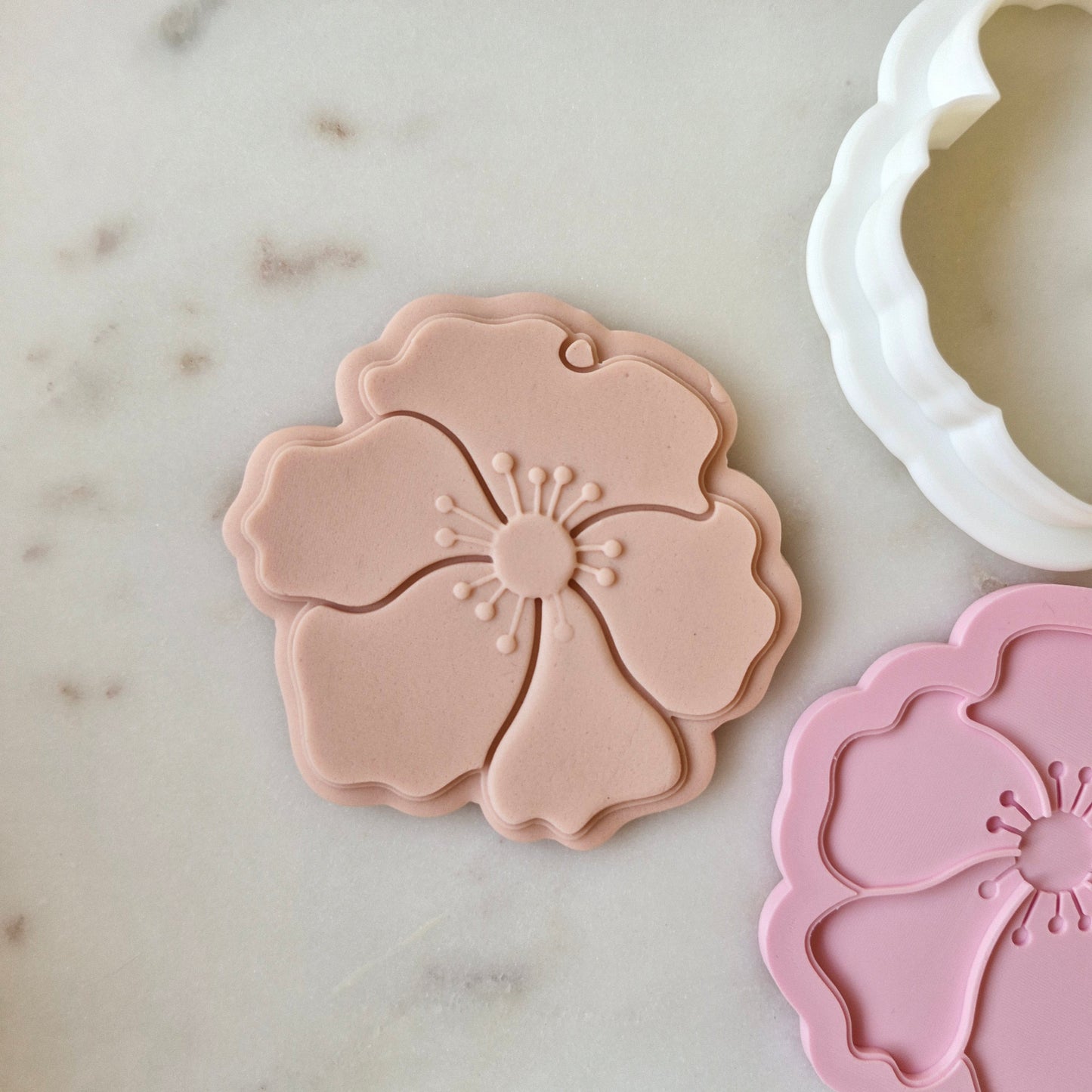 Poppy Cookie Cutter and Deboss Stamp zoomed out, on white marble background