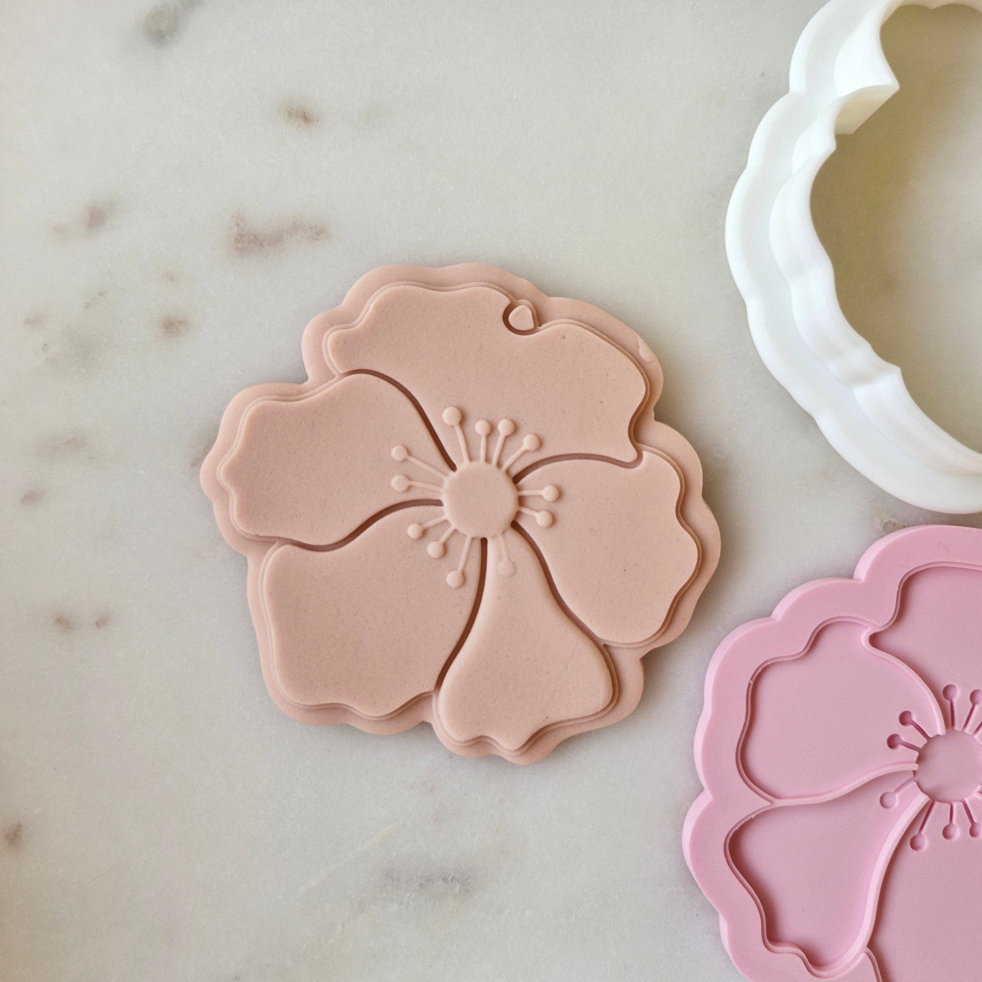 Poppy Cookie Cutter and Deboss Stamp zoomed out, on white marble background
