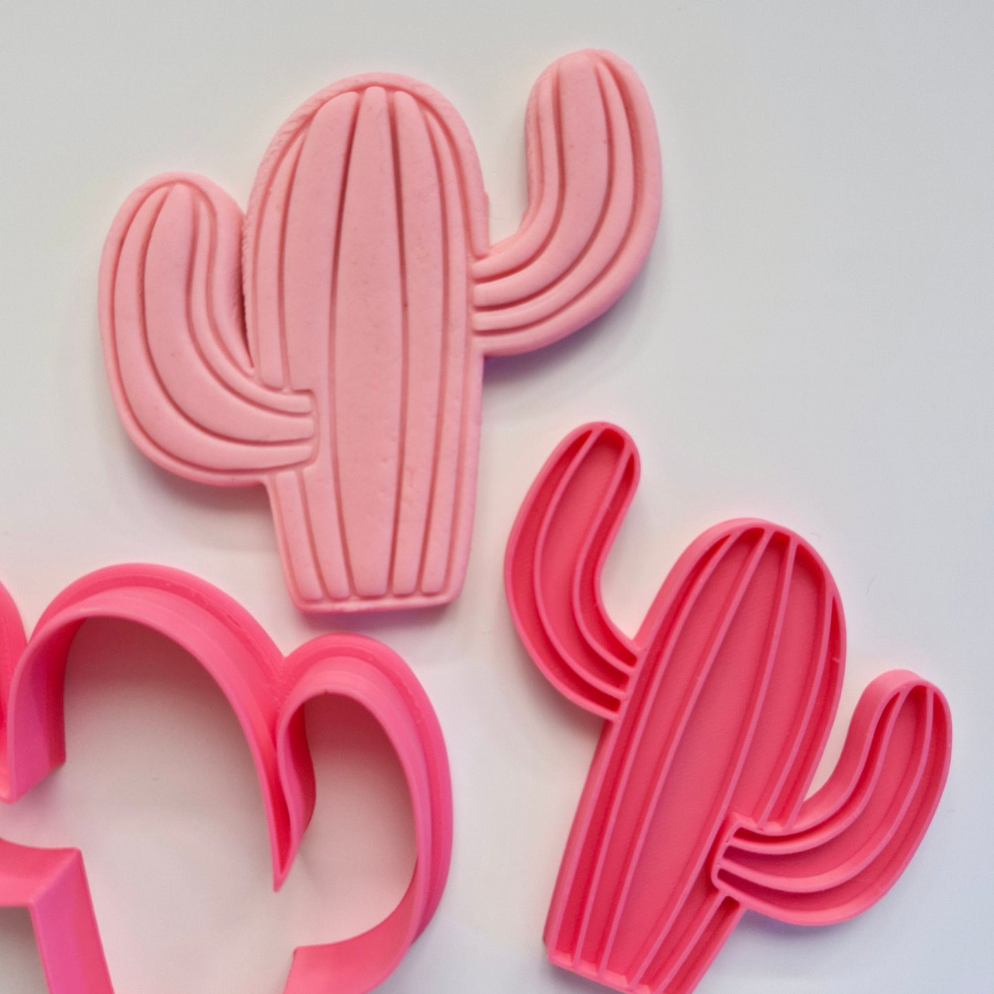 pink cookie cutter and stamp on pink fondant making the shape of a plain cactus. Cactus Cookie Cutter and Emboss Stamp - Baking Tool