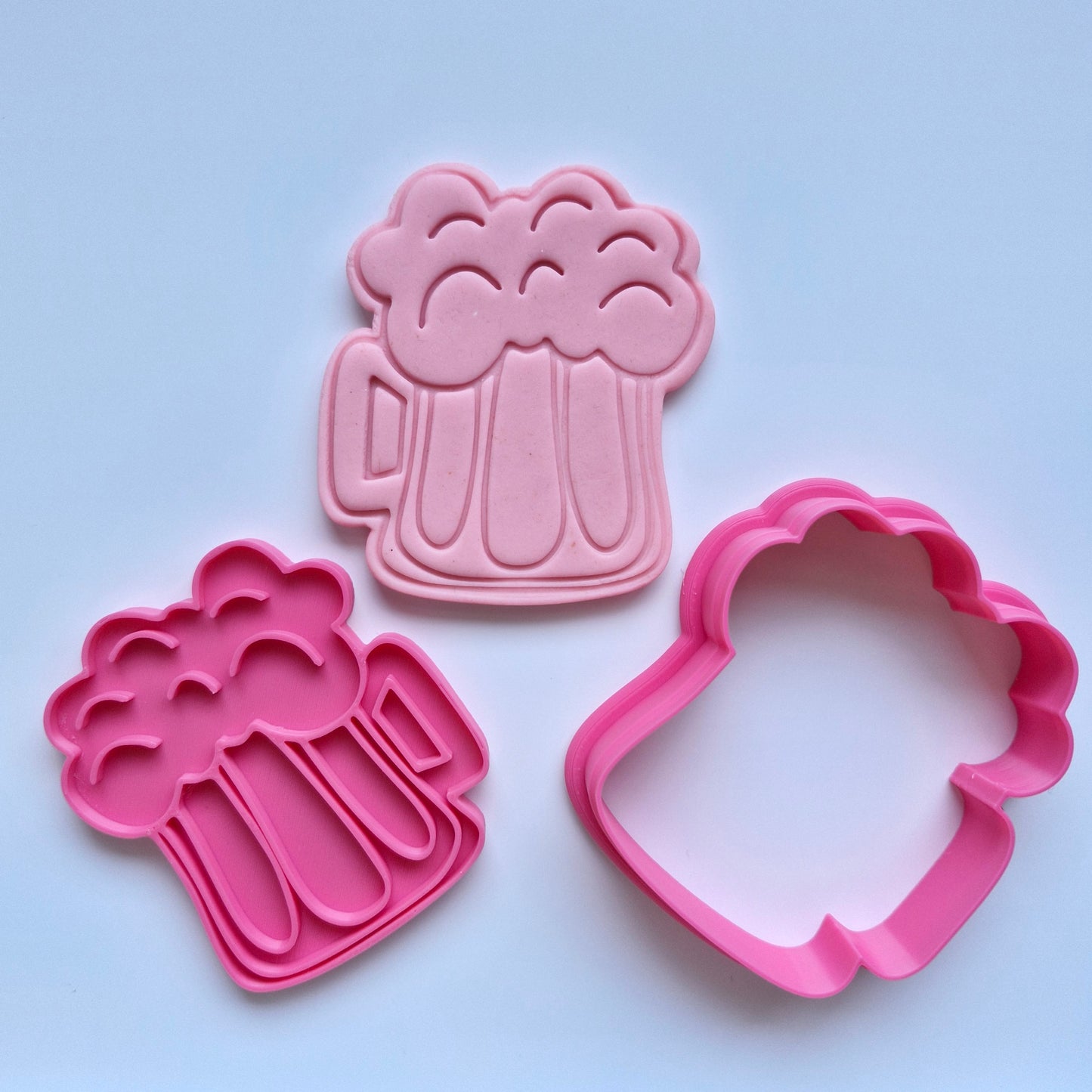 pink cookie cutter and stamp, stamped on pink fondant, with the shape being a chunky beer mug with foam on top on white background Chunky Beer Cookie Cutter and Stamp