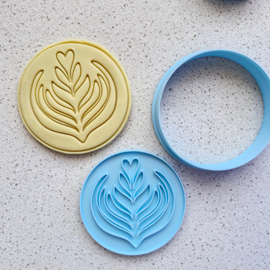 yellow fondant, with blue cookie cutter and stamp, in the shape and imprint of coffee art, on white speckled stone, zoomed out