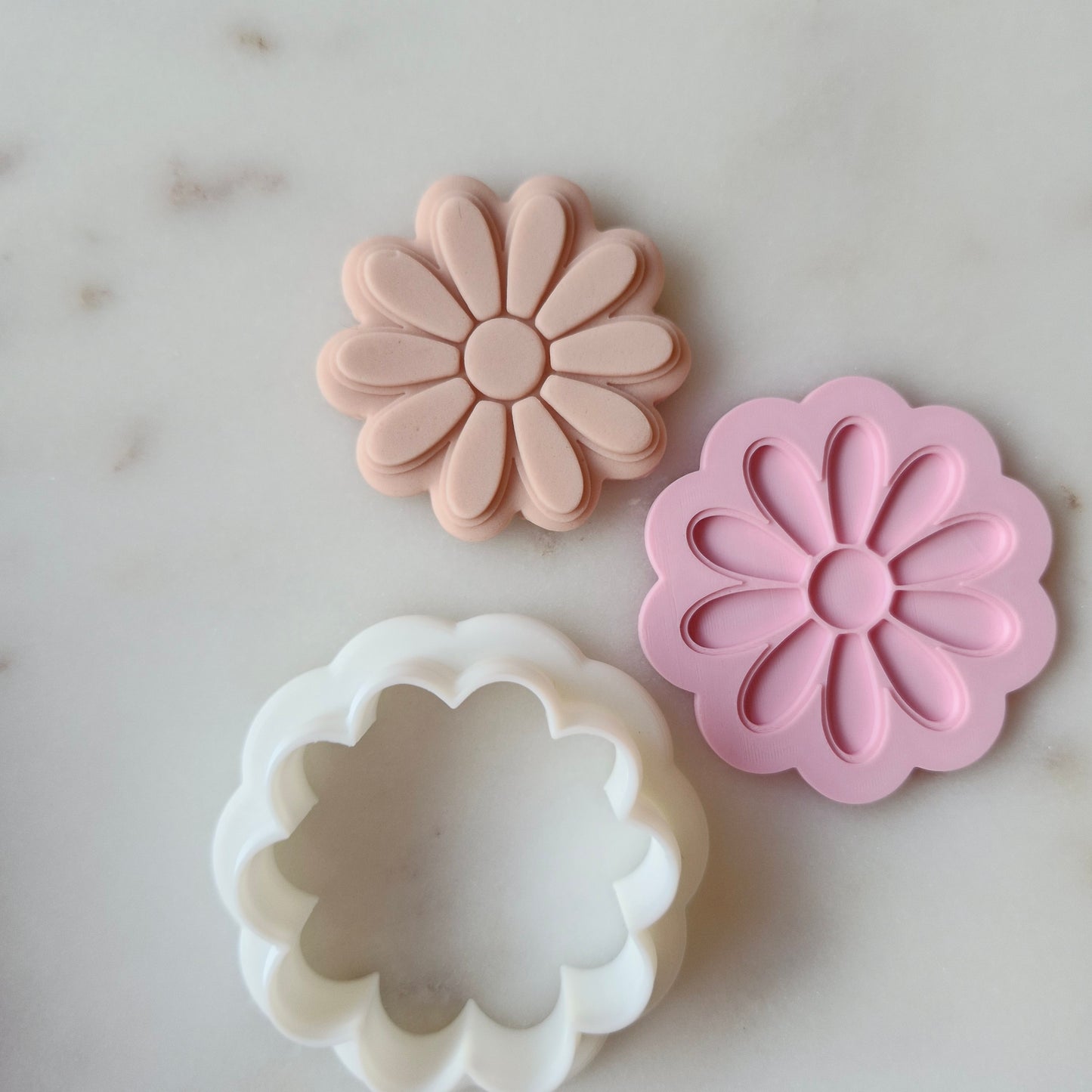 Daisy Cookie Cutter and Deboss Stamp zoomed out on white marble background
