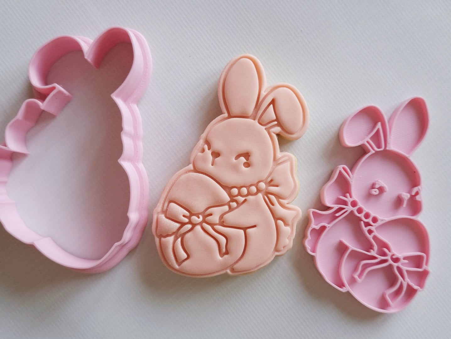 a bunny holding egg wrapped in bow in sugar cookie and cookie cutter and stamp Coquette Bunny Cookie Cutter and Stamp