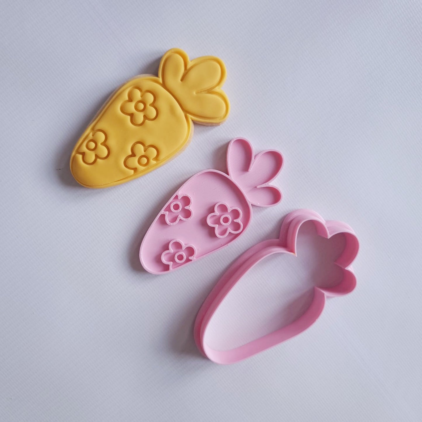 sugar cookie and cookie cutter with stamp in the format of a carrot covered in daisy flowers on white background Floral Easter Carrot Cookie Cutter and Stamp