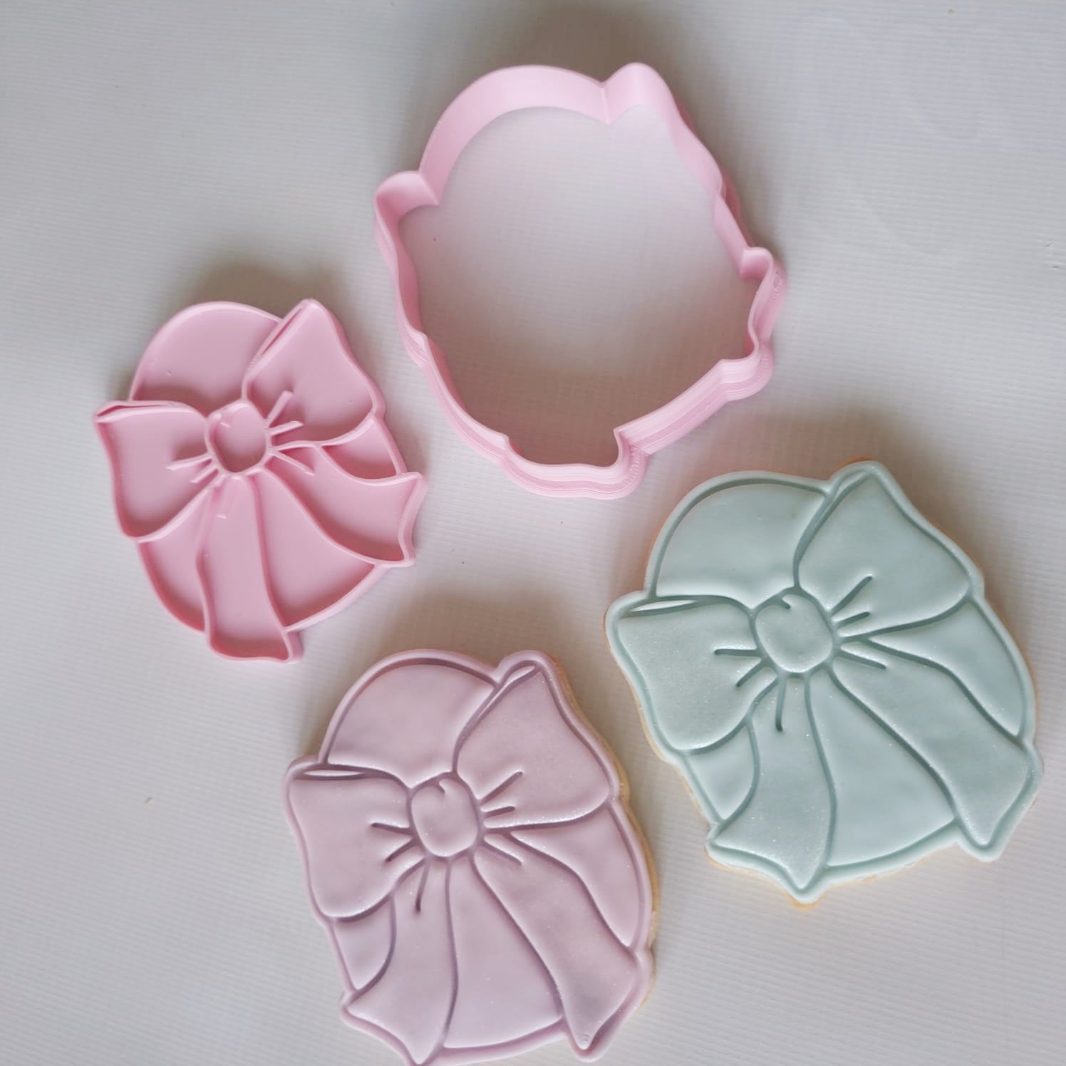 2 sugar cookies with a cookie cutter and stamp of an easter egg with big bow on it Egg with Bow Cookie Cutter and Stamp 