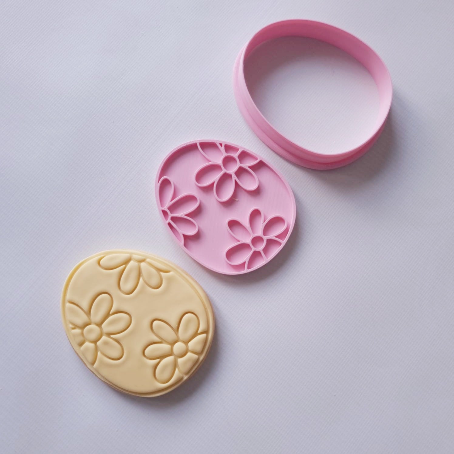sugar cookie with cookie cutter and stamp of the shape of an egg covered in daisy pattern Floral Easter Egg Cookie Cutter and Stamp