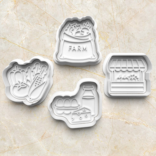 Set of four cookie cutters with farm-themed designs on a beige marble surface. Farmer's Market Cookie Cutter and Emboss Stamp