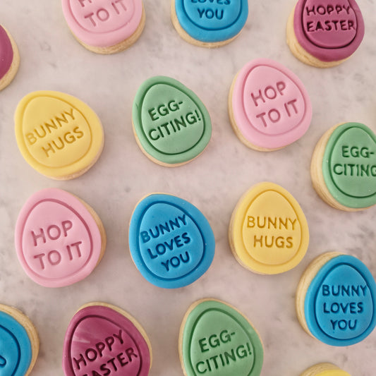 Mini Eggs 4cm Cookie Cutter and Stamp Set multicolored eggs with quotes on them on white marble background