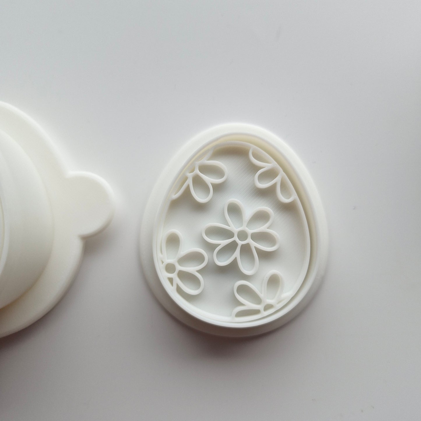 Egg Cake Pop Mould focus on the matching mini cookie cutter and emboss stamp on white background
