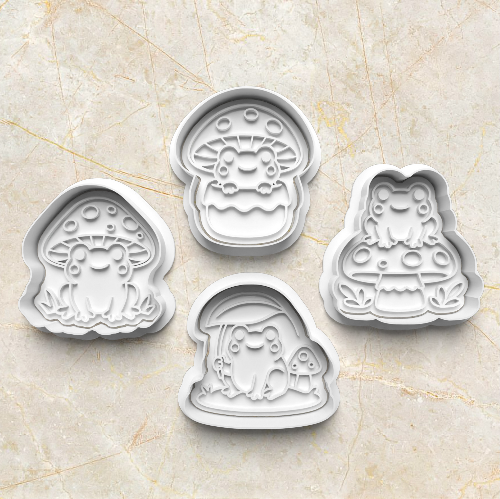 Set of four cartoon-themed frog and mushroom cookie cutters on a beige marble surface Mushroom Frog Set Cookie Cutter and Stamp