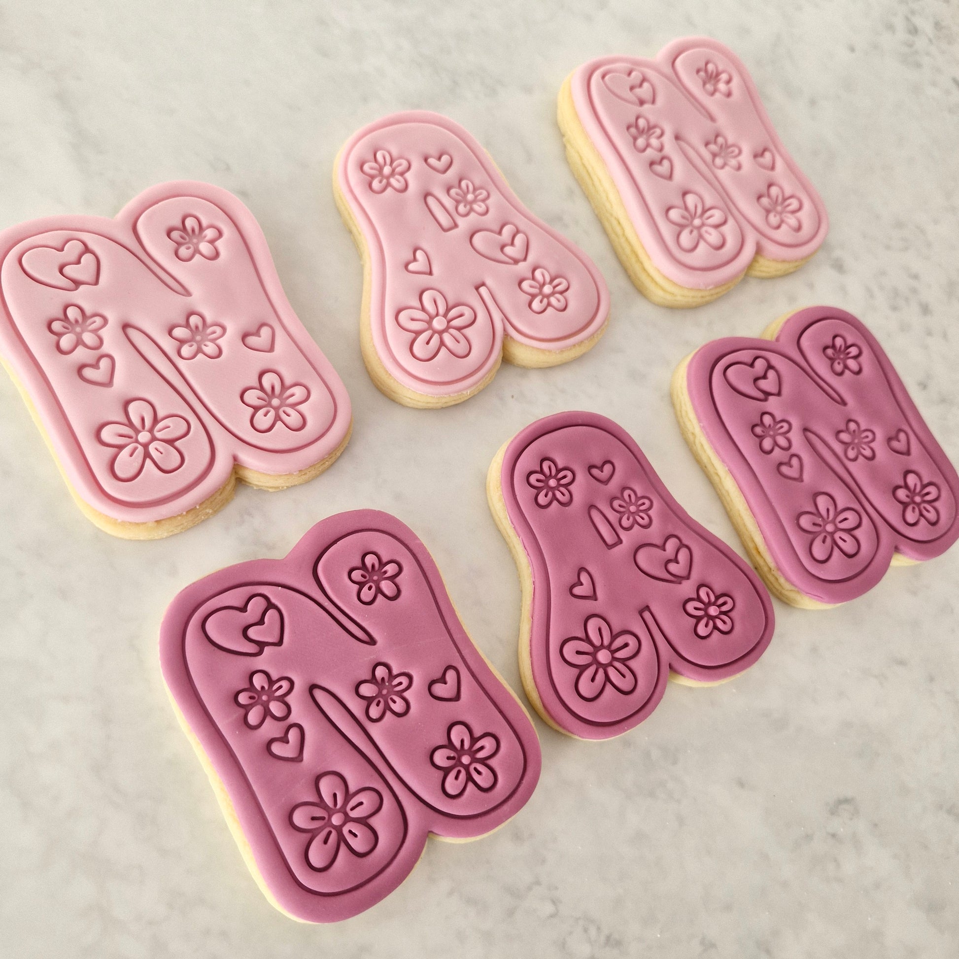 Groovy Nan Cookie Cutter and Stamp Set cookies on the side spelling nan in two colours light pink and dark pink on white marble backgound
