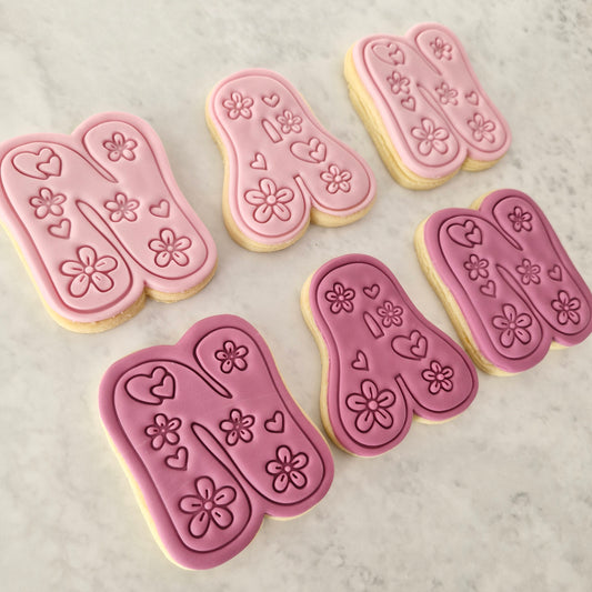 Groovy Nan Cookie Cutter and Stamp Set cookies on the side spelling nan in two colours light pink and dark pink on white marble backgound