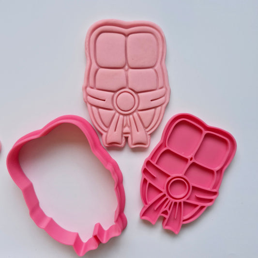 pink fondant, cookie cutter and stamp in the shape of a ninja turtle abs with belt