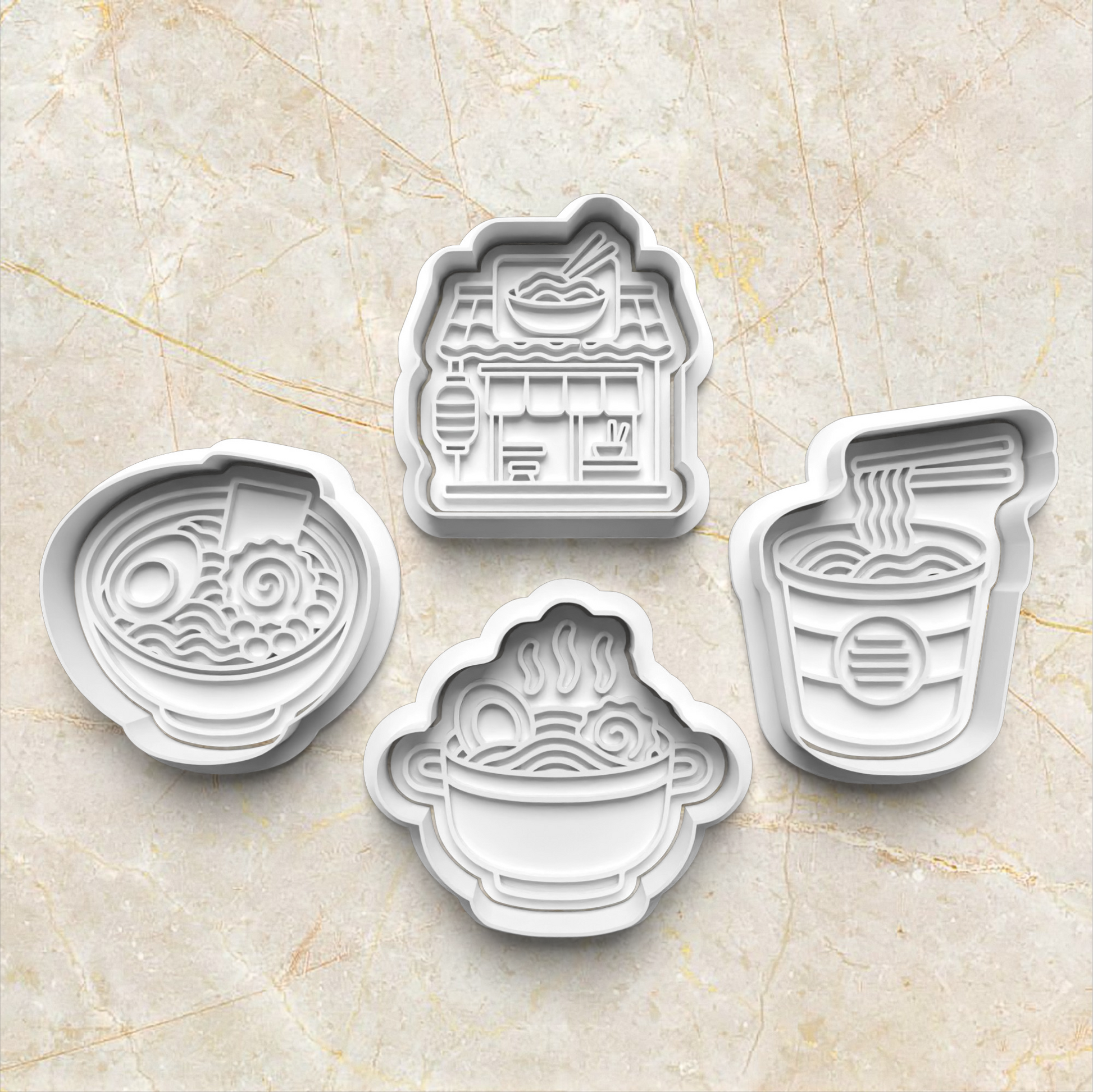 Set of four cookie cutters shaped like a bowl, noodles, a store, and a cup on a beige marble background. Ramen Noodles Cookie Cutter and Stamp