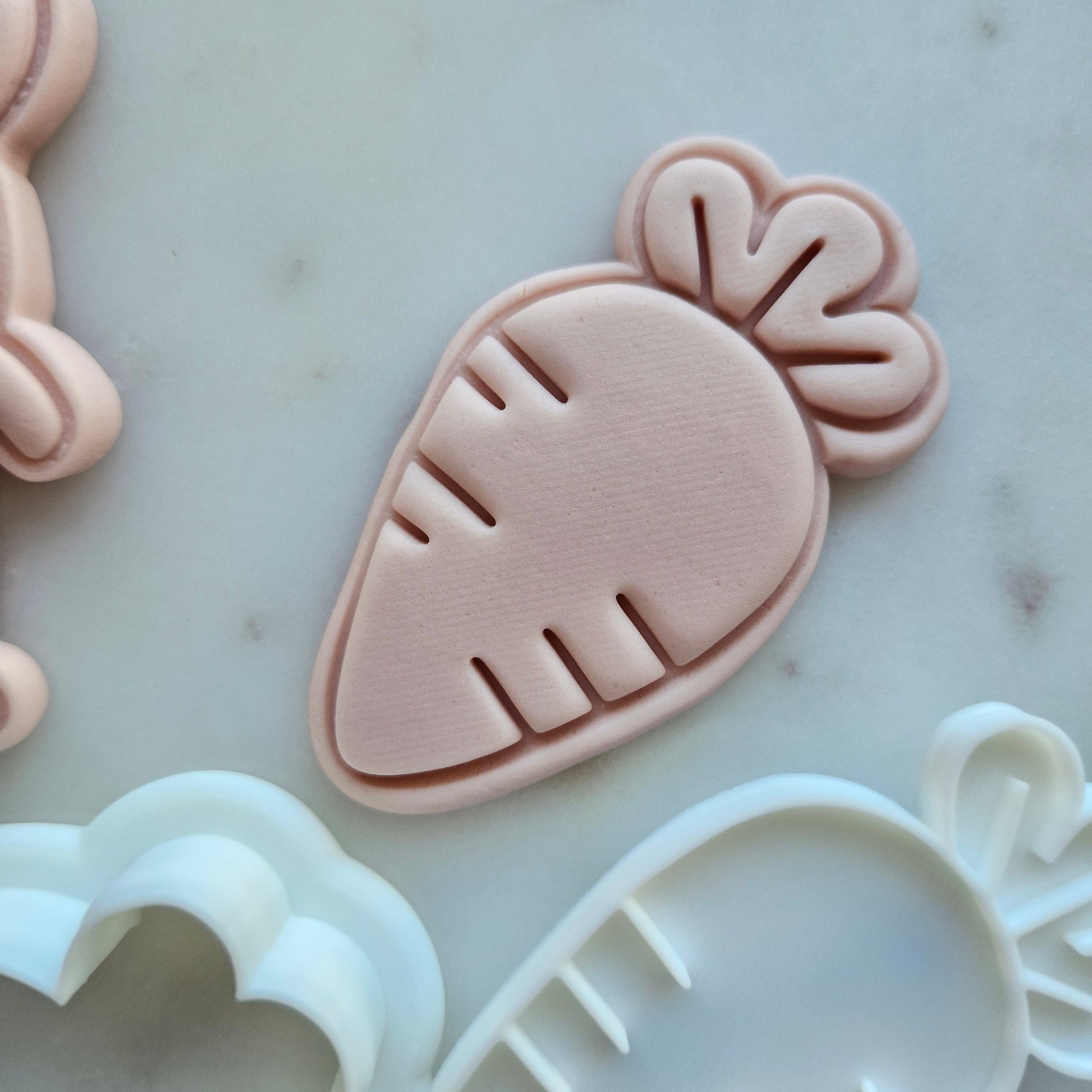 Carrot Cookie Cutter and Stamp - Baking Tool, zoomed in on white marble stone