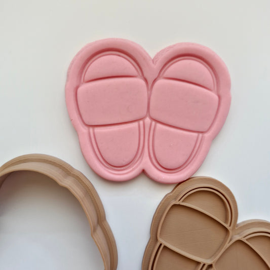 pink fondant, with brown cookie cutter and stamp, in the shape and imprint of slippers, zoomed in 